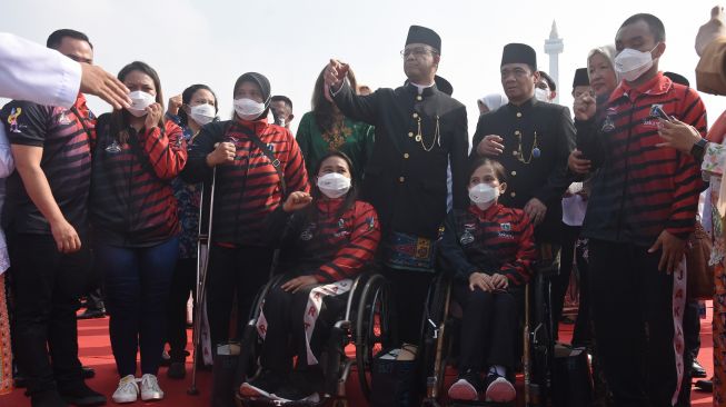 Gubernur DKI Jakarta Anies Baswedan (tengah) didampingi Wakil Gubernur Ahmad Riza Patria (ketiga kanan) berfoto bersama para atlet disabilitas DKI Jakarta usai menghadiri upacara HUT ke-495 Kota Jakarta di kawasan Monas, Jakarta, Rabu (22/6/2022). ANTARA FOTO/Indrianto Eko Suwarso