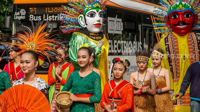 Peserta pawai budaya berjalan mengitari kawasan Taman Lapangan Banteng, Jakarta Pusat, Rabu (22/6/2022). [Suara.com/Alfian Winanto]