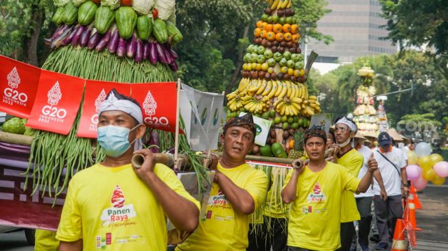 Peserta pawai budaya berjalan mengitari kawasan Taman Lapangan Banteng, Jakarta Pusat, Rabu (22/6/2022). [Suara.com/Alfian Winanto]