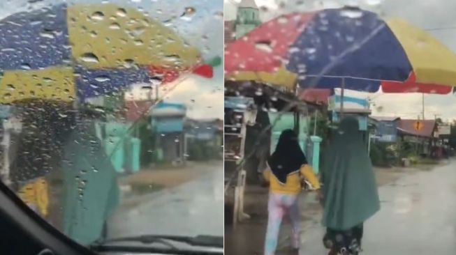 Dua Perempuan Ini Gunakan Payung Jumbo untuk Lindungi Diri dari Hujan, Netizen: Bisa Buat Sekeluarga