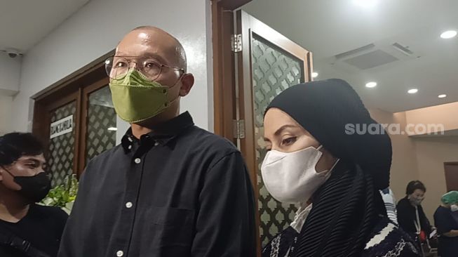 Rima Melati's son, Aditya Tumbuan with his wife, Marissa Tumbuan at the funeral home at RSPAD, Central Jakarta on Thursday (23/6/2022). [Rena Pangesti/Suara.com]