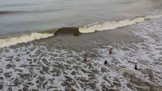 Sejumlah Warga mandi di Pantai Tombawatu, Kecamatan Kapoiala, Konawe, Sulawesi Tenggara, Kamis (23/6/2022). ANTARA FOTO/Jojon