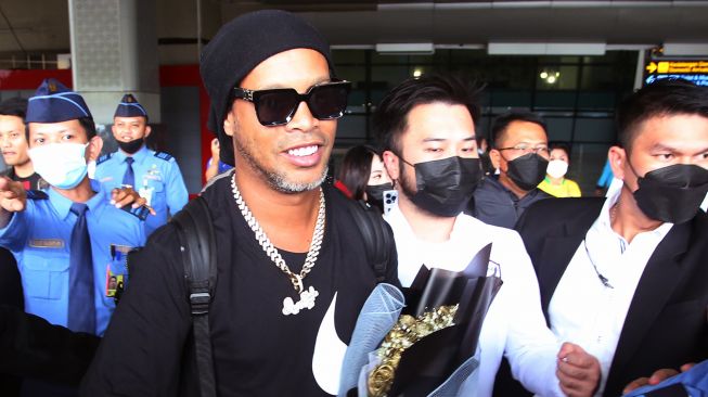 Mantan pesepak bola dunia asal Brasil Ronaldinho (tengah) berjalan keluar terminal setibanya di Bandara Soekarno Hatta, Tangerang, Banten, Jumat (24/6/2022). ANTARA FOTO/Muhammad Iqbal