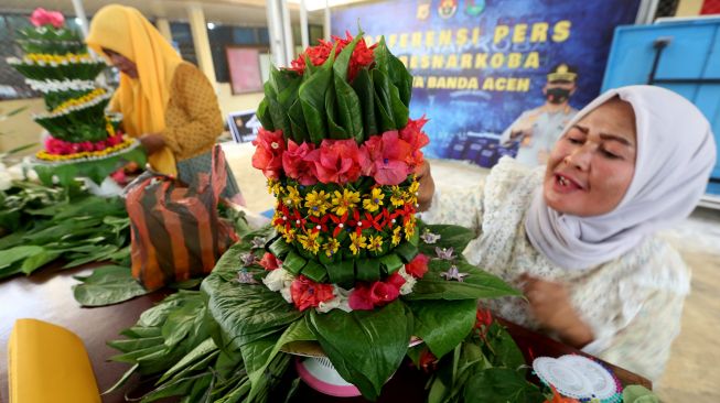 Peserta menata daun sirih saat mengikuti lomba merangkai sirih yang diselenggarakan Polresta Banda Aceh dalam rangka menyambut HUT Ke-76 Bhayangkara di Banda Aceh, Aceh, Jumat (24/6/2022).  ANTARA FOTO/Irwansyah Putra