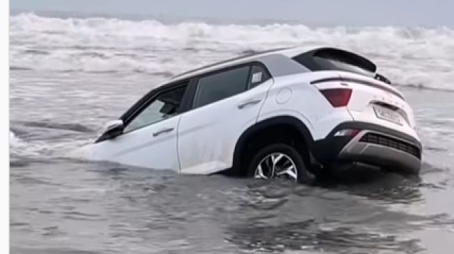 Keasyikan bermain di bibir pantai membuat mobilnya nyungsep di pasir pantai (Instagram)