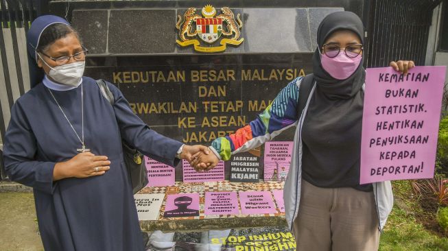 Sejumlah pengunjuk rasa yang tergabung di Koalisi Buruh Migran Berdaulat (KBMB) melakukan aksi di depan Kedutaan Besar Malaysia, Jakarta, Jumat (24/6/2022). ANTARA FOTO/Galih Pradipta