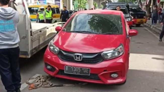 Fakta Mobil Brio Merah Misterius Ditinggal di Jalan Sudirman: Ada Senpi, Stiker SPN Polda Sumsel