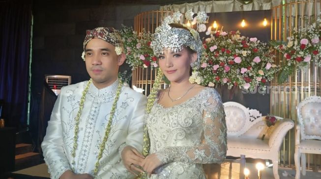 Ikmal Tobing dan Indah Lolita Bahar usai menikah di Hotel Sultan, Jakarta Pusat, Sabtu (25/6/2022) [Suara.com/Rena Pangesti]