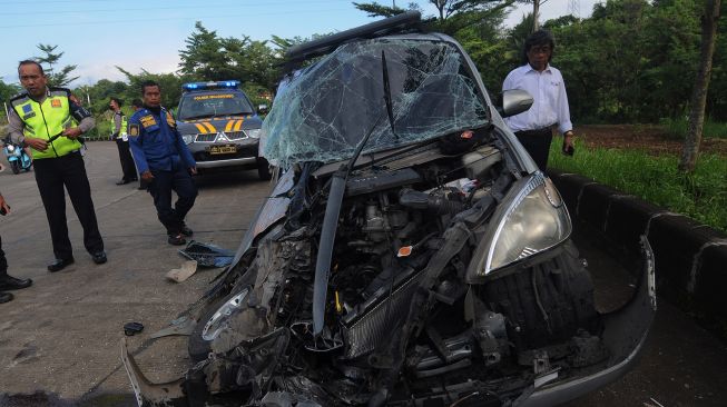 Petugas Satlantas Polres Boyolali melihat kondisi bangkai mobil yang mengalami kecelakaan di Simpang Solidaritas, Boyolali, Jawa Tengah, Senin (27/6/2022). ANTARA FOTO/Aloysius Jarot Nugroho