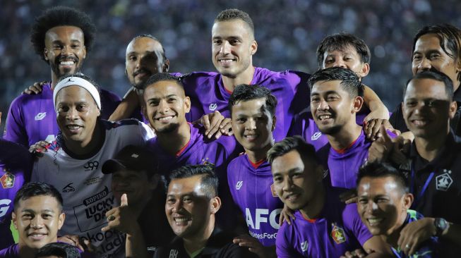 Mantan pesepak bola dunia asal Brazil Ronaldinho (kiri) berfoto dengan para pemain Persik Kediri seusai pertandingan Trofeo Ronaldinho di Stadion Kanjuruhan, Malang, Jawa Timur, Minggu (26/6/2022).  ANTARA FOTO/Rizal Hanafi