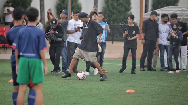 Mantan pesepak bola dunia asal Brazil Ronaldinho (tengah) beraksi di depan para peserta coaching clinic di Unggul Sport Center, Malang, Jawa Timur, Minggu (26/6/2022).  ANTARA FOTO/Rizal Hanafi
