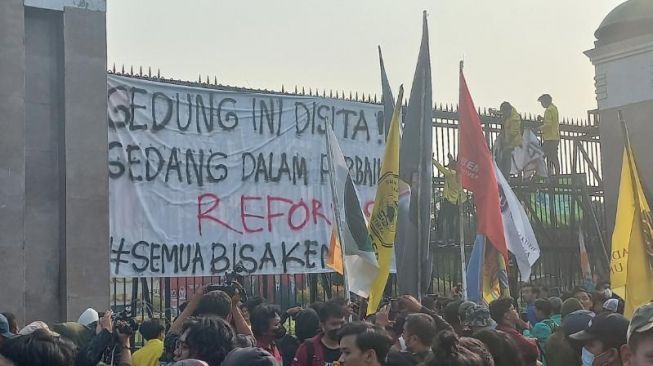 Sejumlah peserta didik mendatangi Gedung DPR RI, Jakarta, Selasa (28/6/2022) untuk melakukan aksi demontrasi menuntut draf RKUHP dibuka. Mereka membentangkan spanduk besar menandakan Gedung DPR RI disita hingga ada perbaikan reformasi. (Suara.com/Bagaskara)