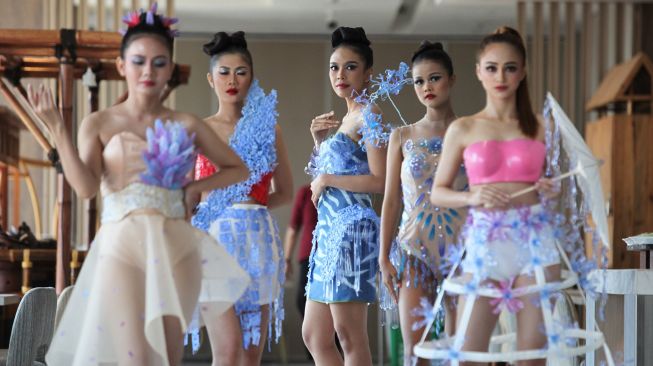 Sejumlah peragawati memamerkan busana dari limbah botol plastik di Surabaya, Jawa Timur, Selasa (28/6/2022).  ANTARA FOTO/Didik Suhartono
