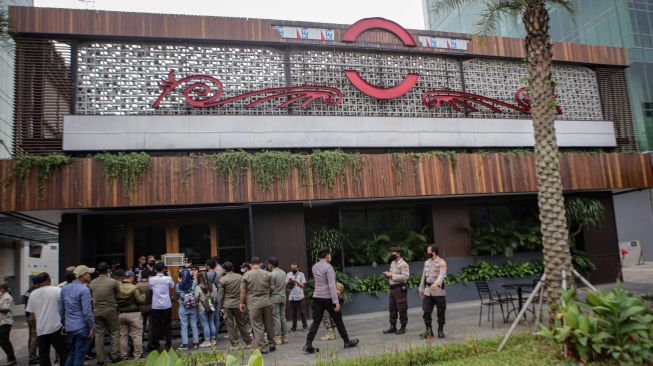 Petugas gabungan berjalan saat penutupan gerai Holywings di kawasan Lippo Karawaci, Kabupaten Tangerang, Banten, Rabu (29/6/2022).  ANTARA FOTO/Fauzan