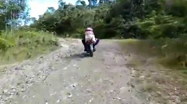 Tangkapan layar video seorang warga meninggal di Papua disebut dibawa menggunakan sepeda motor. [Twitter/@ArnoldBelau]