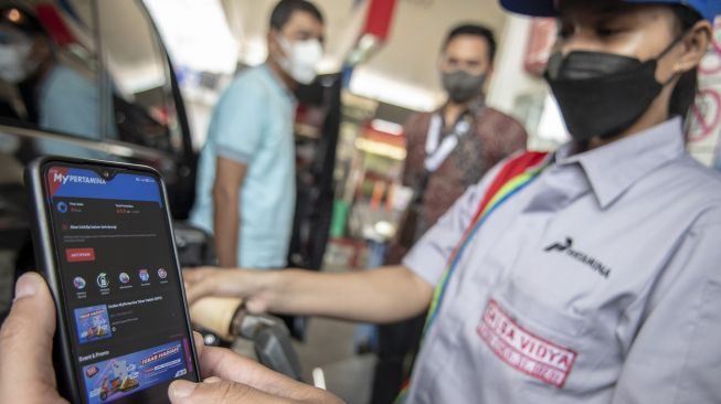 Warga menunjukan aplikasi MyPertamina saat mengisi bahan bakar pertalite di SPBU Pertamina Abdul Muis, Jakarta, Rabu (29/6/2022). ANTARA FOTO/Muhammad Adimaja
