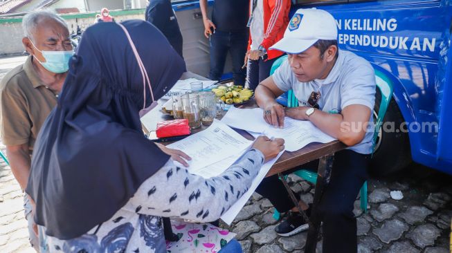 Warga mengunjungi pelayanan keliling Dinas Kependudukan dan Pencatatan Sipil Provinsi DKI Jakarta di halaman Masjid Al Hikmah Hidayah, Cipayung, Jakarta Timur, Rabu (29/6/2022). [Suara.com/Alfian Winanto]