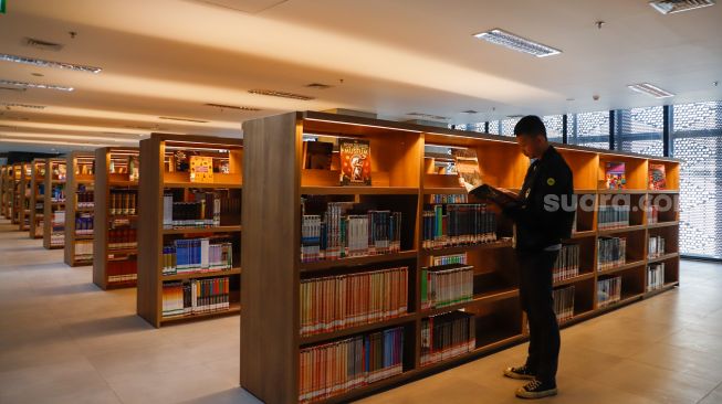 Pengunjung memilih buku di Perpustakaan Umum Daerah Provinsi DKI Jakarta, Taman Ismail Marzuki, Cikini, Jakarta Pusat, Kamis (30/6/2022). [Suara.com/Alfian Winanto]