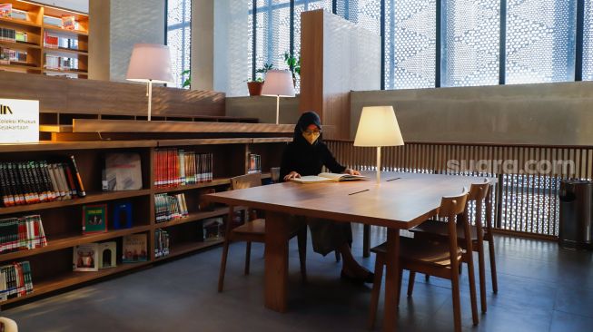 Pengunjung membaca buku di Perpustakaan Umum Daerah Provinsi DKI Jakarta, Taman Ismail Marzuki, Cikini, Jakarta Pusat, Kamis (30/6/2022). [Suara.com/Alfian Winanto]