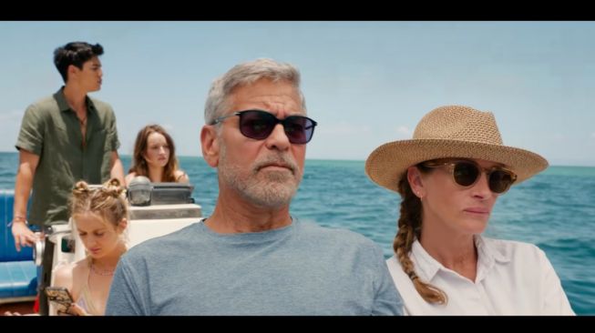 Tangkapan layar Maxime Bouttier berperan menjadi Kadek (belakang) dan beradu akting dengan George Clooney dan Julia Roberts dalam trailer "Ticket to Paradise". (ANTARA/HO/Universal Pictures)