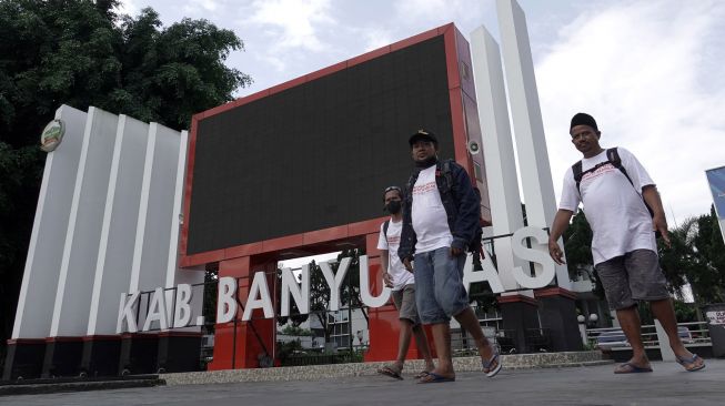 Tiga warga Desa Sumber Wuluh Pangat (kanan), bersama Nor Holik (kanan) dan Masbud (kiri) berjalan melintasi komplek Alun-alun Purwokerto di Banyumas, Jateng, Jumat (1/7/2022). ANTARA FOTO/Idhad Zakaria
