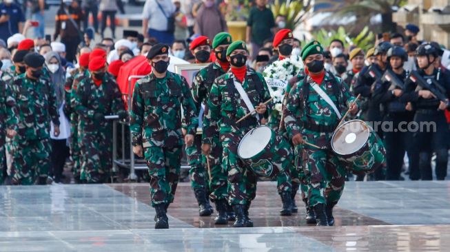 Sejumlah prajurit TNI membawa peti berisi jenazah Menteri Pendayagunaan Aparatur Negara dan Reformasi Birokrasi (Menpan RB) Tjahjo Kumolo saat prosesi pemakaman di Taman Makam Pahlawan, Kalibata, Jakarta Selatan, Jumat (1/7/2022). [Suara.com/Alfian Winanto]