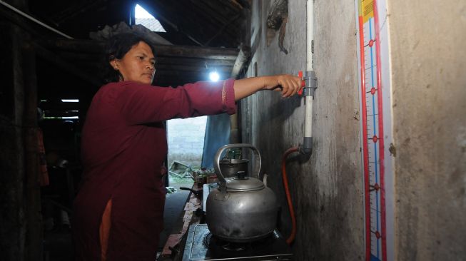 Warga membuka keran saluran biogas kotoran sapi untuk bahan bakar kompor saat akan memasak di Dangean, Gedangan, Cepogo, Boyolali, Jawa Tengah, Kamis (30/6/2022).  ANTARA FOTO/Aloysius Jarot Nugroho