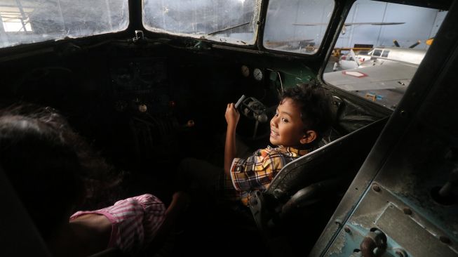 Dua anak duduk di dalam kokpit pesawat terbang koleksi Museum Pusat TNI AU Dirgantara Mandala di Bantul, DI Yogyakarta, Jumat (1/7/2022). ANTARA FOTO/Prasetia Fauzani