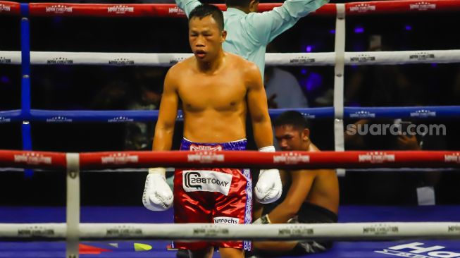 Petinju Indonesia Daud Yordan (merah) usai menjatuhkan petinju Thailand Panya Uthok (hitam) dalam laga mempertahankan gelar juara kelas ringan super World Boxing Council atau WBC Asian Boxing Council Silver di Balai Sarbini, Jakarta Pusat, Jumat (1/7/2022). [Suara.com/Alfian Winanto]