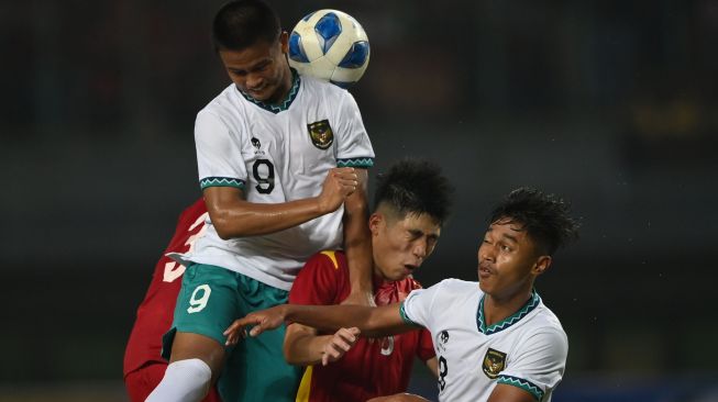 Pesepak bola Tim Nasional Indonesia U-19 Hokky Caraka (kiri) berebut bola dengan pesepak bola Tim Nasional Vietnam U-19 Trinh Hoang Canh (kedua kanan) dalam laga penyisihan Grup A Piala AFF U-19 2022 di Stadion Patriot Candrabhaga, Bekasi, Jawa Barat, Sabtu (2/7/2022). [ANTARA FOTO/Aditya Pradana Putra/rwa]