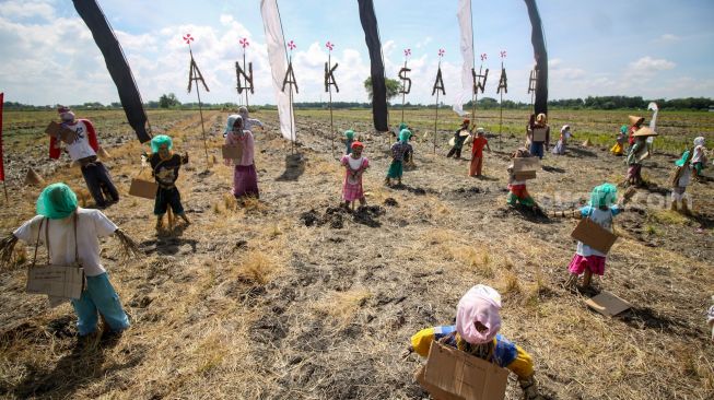 Sejumlah orang-orangan sawah berbahan jerami terpasang pada Festival Anak Sawah di kawasan persawahan Kampung Lali Gadget (KLG), Desa Pagerngumbuk, Wonoayu, Sidoarjo, Jawa Timur, Minggu (3/7/2022). [ANTARA FOTO/Umarul Faruq/nym]