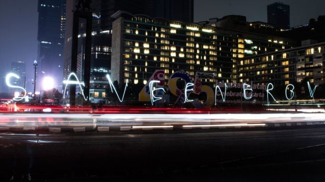 Aktivis lingkungan membuat tulisan "Save Energy" saat pelaksanaan Earth Hour di kawasan Bundaran HI, Jakarta, Sabtu(2/7/2022). [ANTARA FOTO/Muhammad Adimaja/rwa]