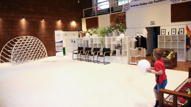 Seorang anak bermain di dalam masjid Ibnu Rusyd-Goethe yang mengibarkan bendera pelangi di dinding luar bangunannya di Berlin, Jerman, Jumat (1/7/2022). [Adam BERRY/AFP]
