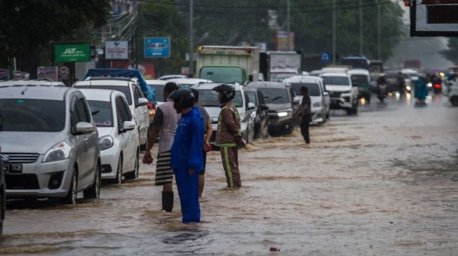 Sejumlah relawan mengatur arus lalu lintas di jalan nasional Ahmad Yani yang terendam banjir di Kecamatan Landasan Ulin, Banjarbaru, Kalimantan Selatan, Senin (4/7/2022). [ANTARA FOTO/Bayu Pratama S/aww]