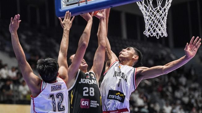 Pebasket Timnas Indonesia Derrick Michael (kanan) dan Muhammad Arighi (kiri) berusaha menghalangi pebasket Timnas Yordania Mahmoud Hazaymeh (tengah) dalam Kualifikasi FIBA World Cup 2023 Grup C Zona Asia Window III di Istora Senayan, Jakarta, Senin (4/7/2022). [ANTARA FOTO/M Risyal Hidayat/wsj]