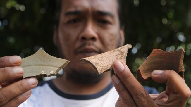 Arkeolog dari Balai Pelestarian Cagar Budaya (BPCB) Jawa Timur menunjukkan pecahan gerabah dari Dinasti Yuan dan Dinasti Ming yang ditemukan saat ekskavasi di situs Arca Dwarapala, Singosari, Malang, Jatim, Senin (4/7/2022). [ANTARA FOTO/Ari Bowo Sucipto/aww]