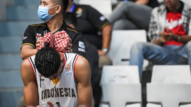 Pebasket Timnas Indonesia Derrick Michael mendapatkan perawatan dari ofisial saat melawan Timnas Yordania dalam Kualifikasi FIBA World Cup 2023 Grup C Zona Asia Window III di Istora Senayan, Jakarta, Senin (4/7/2022). [ANTARA FOTO/M Risyal Hidayat/wsj]