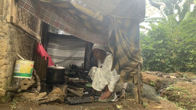 Mak Idah (52) saat menyiapkan kayu bakar untuk memasak [Fauzi/Suara.com]