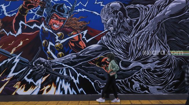 Warga melintas di dekat mural kolaborasi bergambar Thor di Terowongan Kendal, Jakarta Pusat, Selasa (5/7/2022). [Suara.com/Alfian Winanto]