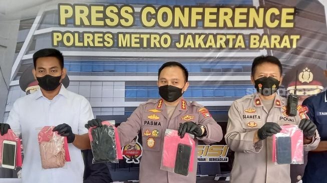 Polisi memperlihatkan barang bukti dalam ungkap kasus pornografi lewat media sosial ManggoLive di Polres Metro Jakarta Barat, Rabu (6/7/2022). [Suara.com/Faqih Fathurrahman]