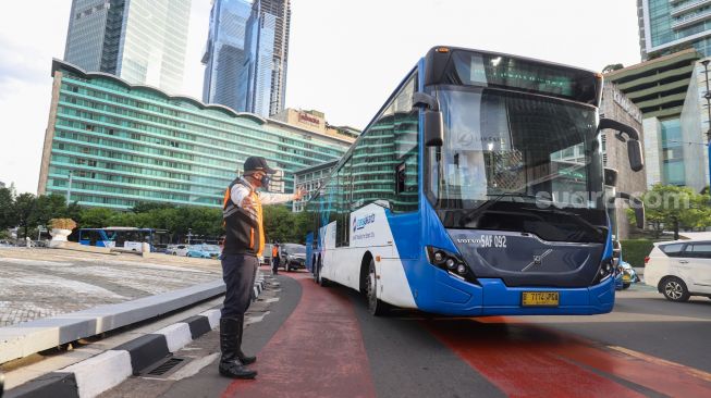 Petugas gabungan yang terdiri dari Ditlantas Polda Metro Jaya dan Dinas Perhubungan (Dishub) DKI Jakarta mengatur arus lalu lintas di kawasan Bundaran Hotel Indonesia (HI) , Jakarta Pusat, Rabu (6/7/2022). [Suara.com/Alfian Winanto]