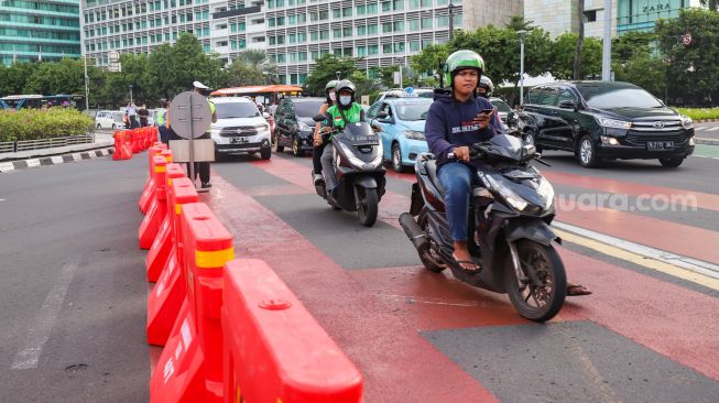 Petugas gabungan yang terdiri dari Ditlantas Polda Metro Jaya dan Dinas Perhubungan (Dishub) DKI Jakarta mengatur arus lalu lintas di kawasan Bundaran Hotel Indonesia (HI) , Jakarta Pusat, Rabu (6/7/2022). [Suara.com/Alfian Winanto]