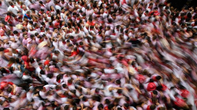 Para peserta berlari di depan banteng selama acara "encierro" (lari banteng) saat festival San Fermin di Pamplona, Spanyol, Kamis (7/7/2022). [MIGUEL RIOPA / AFP]
