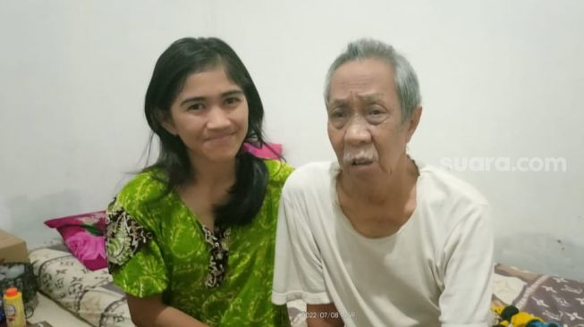 Pak Ogah with his nephew, Harmah at his home in the Bekasi area, West Java, Friday (8/7/2022). [Rena Pangesti/Suara.com]