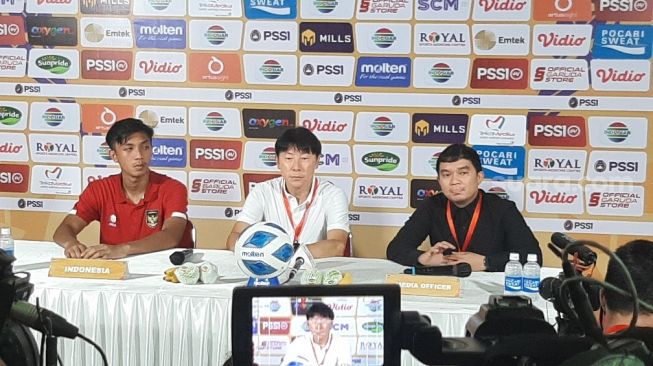 Pelatih Timnas Indonesia U-19 Shin Tae-yong (tengah) dan Rabbani Tasnim (kiri) saat konferensi pers usai laga kontra Filipina, Jumat (8/7/2022) malam WIB. (Suara.com/Adie Prasetyo Nugraha).