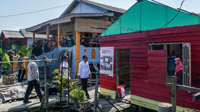 Presiden Joko Widodo (tengah) meninjau proyek penataan Kampung Belawan Bahari di Belawan, Kota Medan, Sumatera Utara, Kamis (7/7/2022). [ANTARA FOTO/Fransisco Carolio/Lmo/hp]