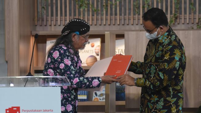 Gubernur DKI Jakarta Anies Baswedan (kanan) menerima Buku berjudul "Sejuta Puisi untuk Jakarta" dari Sastrawan Jose Rizal Manua (kiri) saat peresmian Perpustakaan Jakarta dan Pusat Dokumentasi Sastra HB Jassin di Taman Ismail Marzuki (TIM), Cikini, Jakarta, Kamis (7/7/2022). [ANTARA FOTO/Indrianto Eko Suwarso]