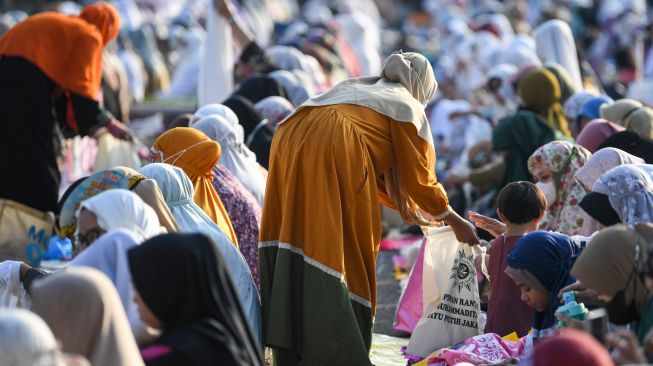 Umat Islam berinfak di sela-sela mendengarkan khotbah usai melaksanakan salat Idul Adha 1443 Hijriah di halaman Jakarta International Equestrian Park (JIEP) Pulomas, Jakarta, Sabtu (9/7/2022). [ANTARA FOTO/M Risyal Hidayat/nym]
