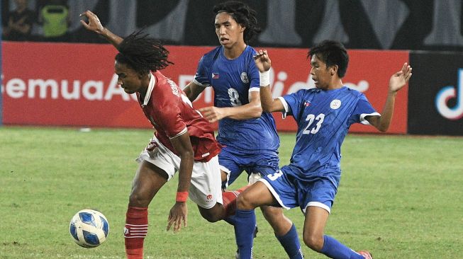 Pesepak bola Tim Nasional Indonesia U-19 Ronaldo Kwateh (kiri) menguasai bola dengan dikawal dua pesepak bola Tim Nasional Filipina U-19 dalam laga penyisihan Grup Piala AFF U-19 2022 di Stadion Patriot Chandrabhaga, Bekasi, Jawa Barat, Jumat (8/7/2022). [ANTARA FOTO/Aditya Pradana Putra/aww]