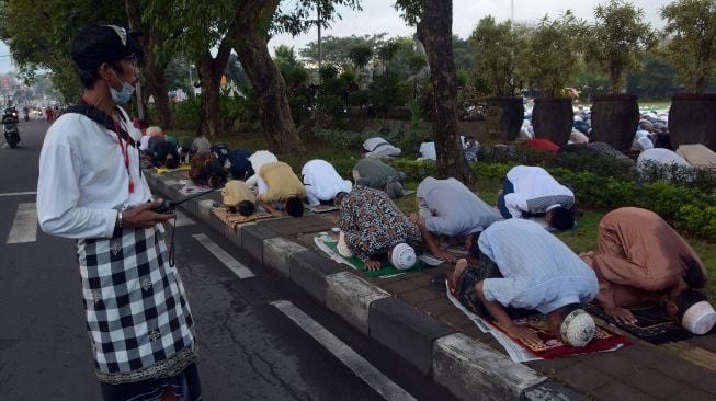 Pecalang atau satuan pengamanan desa adat Bali berjaga saat umat Islam melaksanakan Shalat Idul Adha 1443 Hijriah di Denpasar, Bali, Minggu (10/7/2022).  Antara Foto